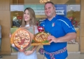 Torcedor italiano posa para foto ao lado de promotora da Reis Magos, que distribuiu pizzas