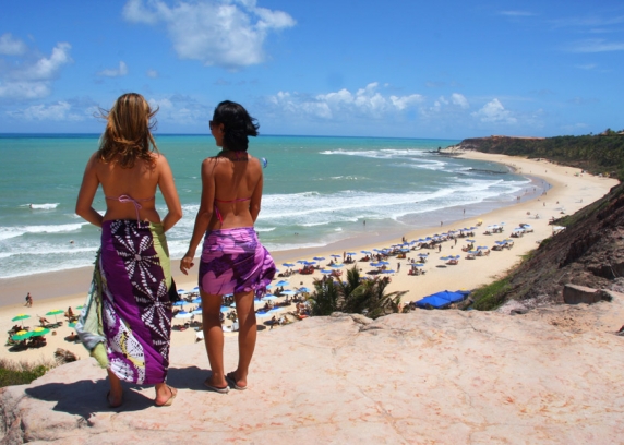 Turistas apreciam a beleza da praia do Amor do alto da falésia, um mirante natural.