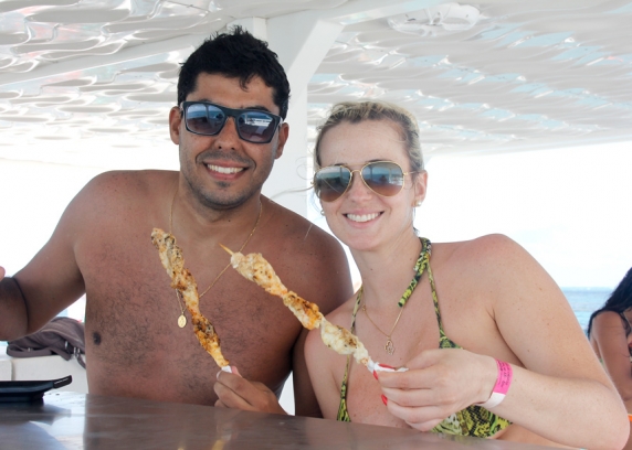 O casal Isabella e Antônio, do município de Passos Maia, no Oeste de SC, comendo espetinho de lagosta na plataforma de apoio do mergulho da Maracajaú Diver.