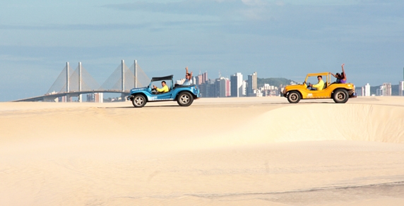 Passeio de buggy nas dunas móveis de Genipabu, com a cidade de Natal ao fundo.